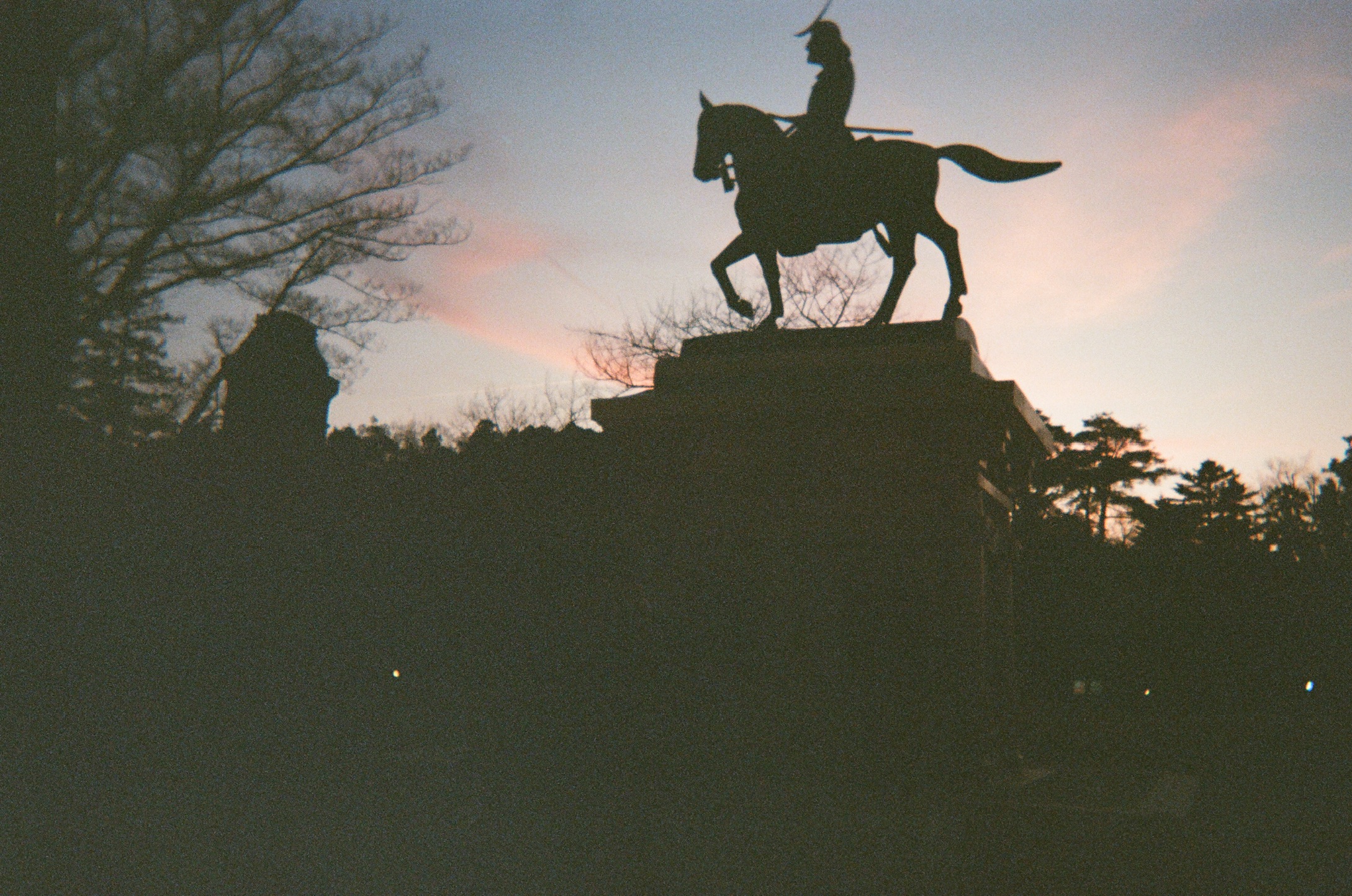 Date Masamune statue silhouetted against a pink and blue sunset sky — Sendai, Tohoku