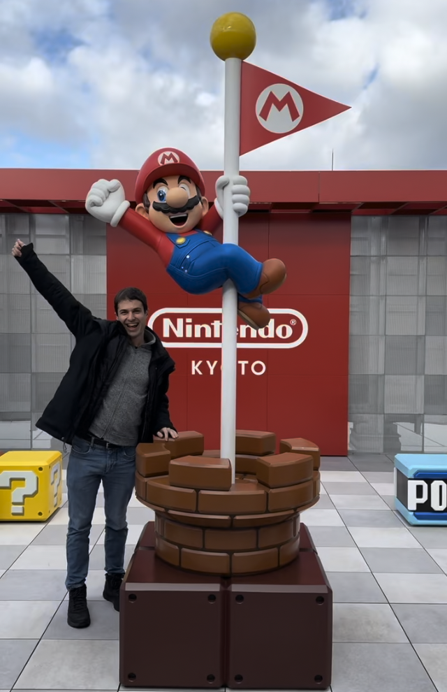 Evan at Nintendo Kyoto in front of the Mario flag pole