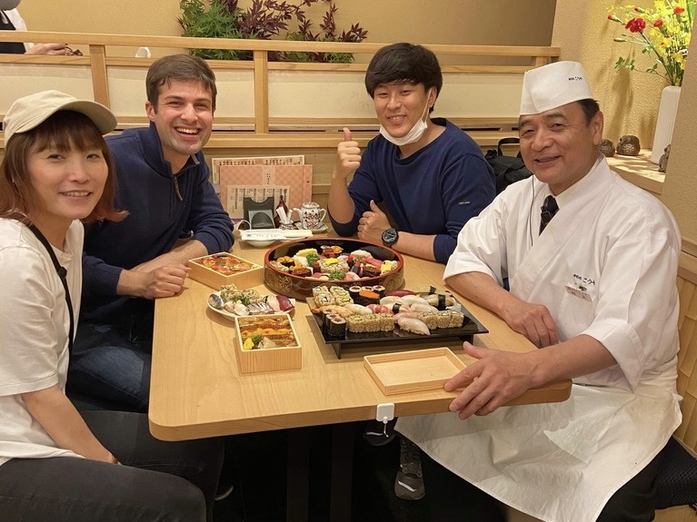 Evan with the sushi chef and colleagues — the kind of relationship the work was about